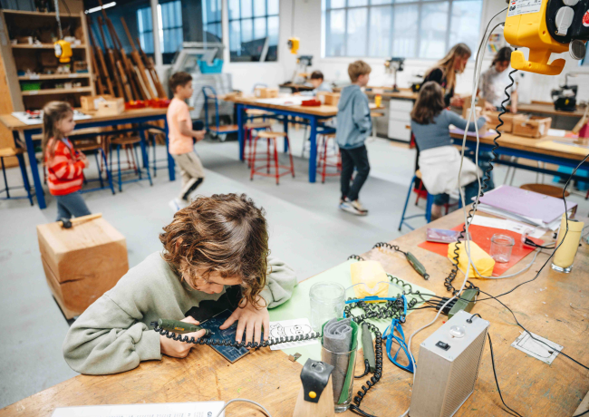 klaslokaal met kinderen aan het solderen